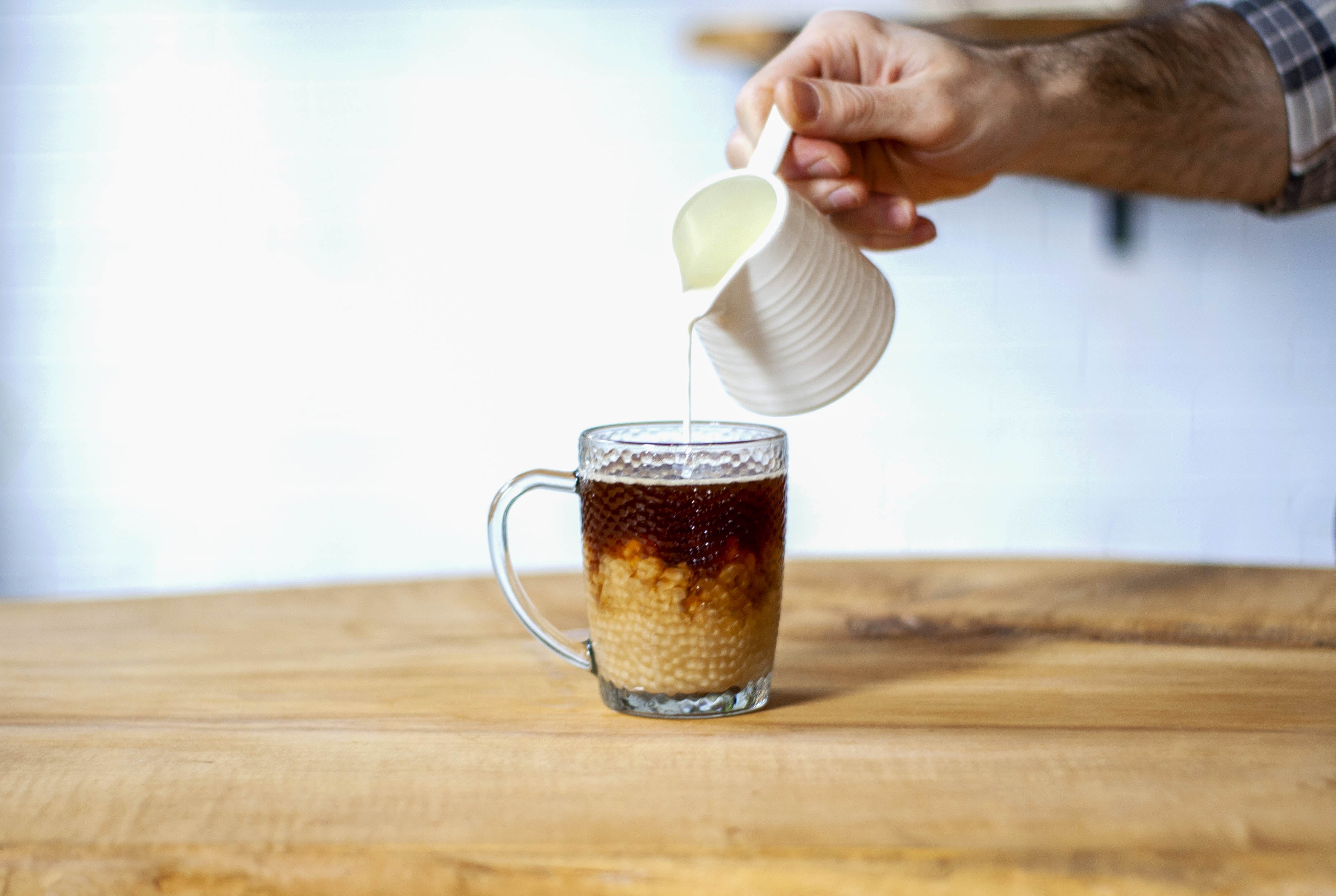 cafe filtre dans une tasse. Une personne y verse du lait